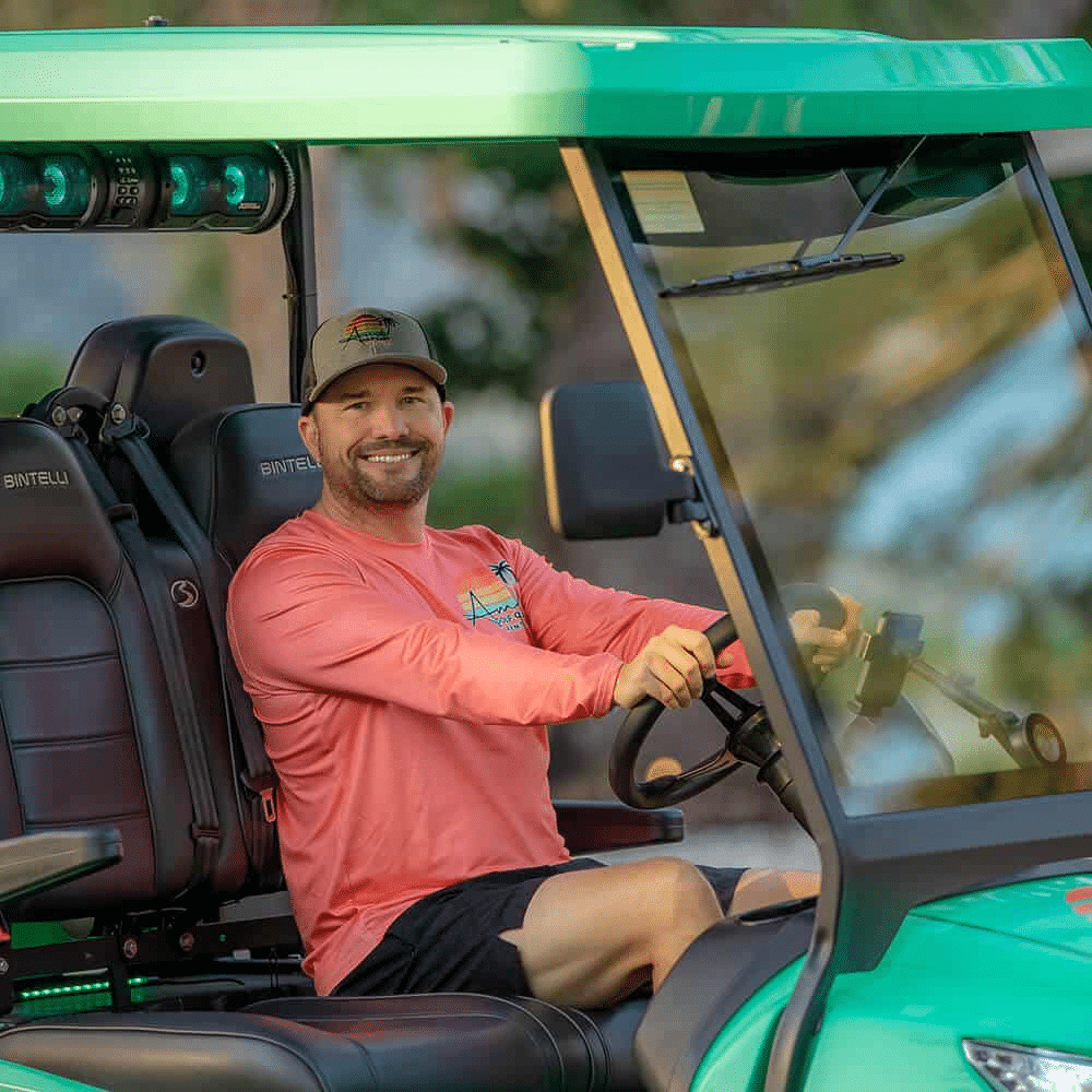AMI Golf Cart Rentals customer enjoying a green electric golf cart rental on Anna Maria Island, a convenient and eco-friendly way for families to explore the island.