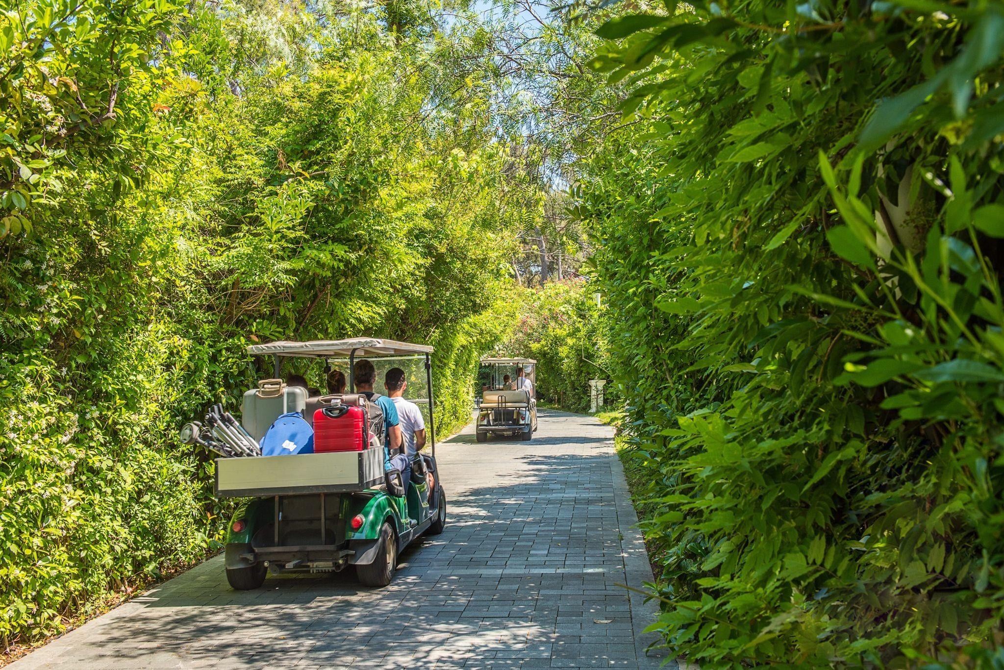 Vacationing family driving an Anna Maria Island golf cart rental loaded with luggage, showing how to park a golf cart safely while cruising island pathways.