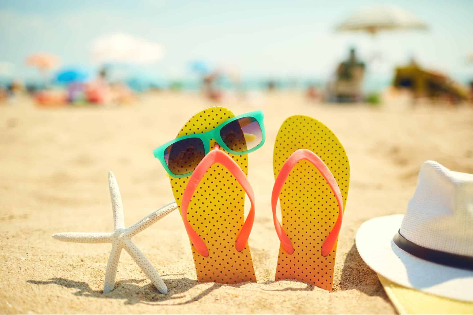 Flip flops, sunglasses, and starfish on the sand during an Anna Maria Island vacation.