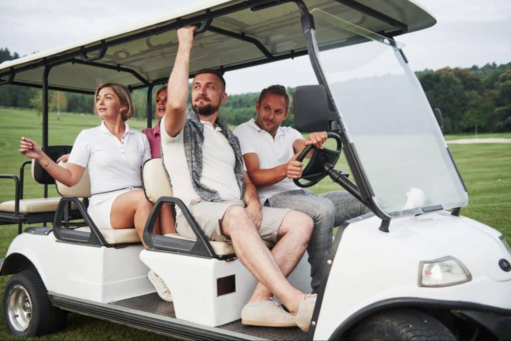 Friends riding a golf cart to explore Anna Maria Island beaches.